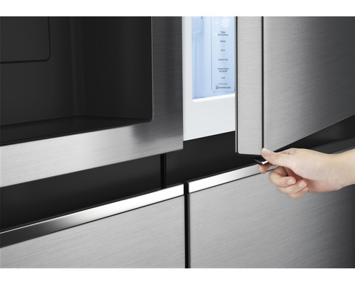 Detailopname van een koelkast waarbij iemand een deur opent om het interieur te laten zien.