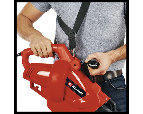 Een persoon bedient een bladblazer met draagriem.