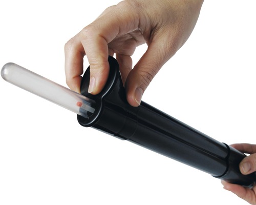 Close-up van een hand die een test in een testapparaat plaatst