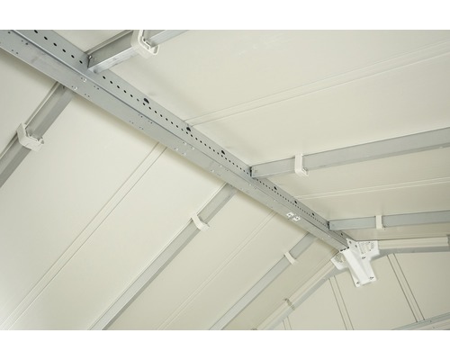 Interieur van een tuinhuis met metalen balken ter stabilisatie van het dak.