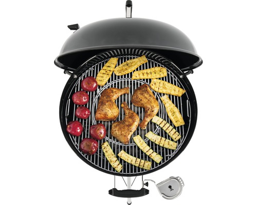 Bolvormige barbecue met gegrilde kip, courgette en aardappelen.