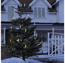 Kerstboom met elektrische kaarsverlichting voor een huis