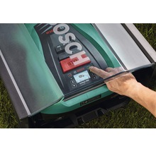Bosch logo op een robotmaaier met een hand die op een knop drukt