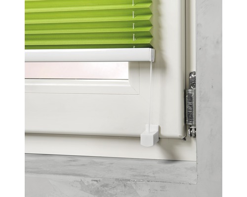 Groen plisségordijn voor het raam