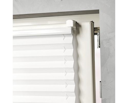 Close-up van een wit plisségordijn op een raam