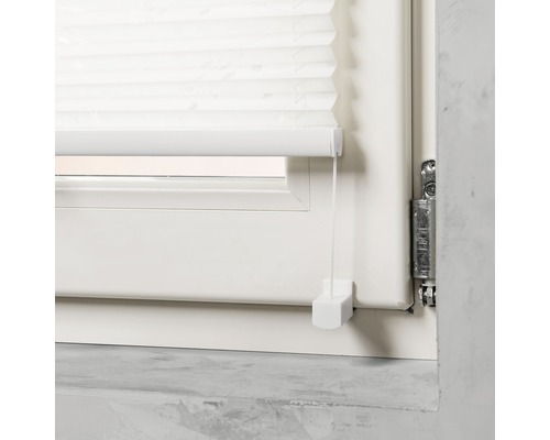 Detailopname van een wit plisségordijn voor het raam