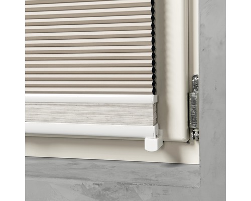 Detailopname van een plisségordijn op een raam.