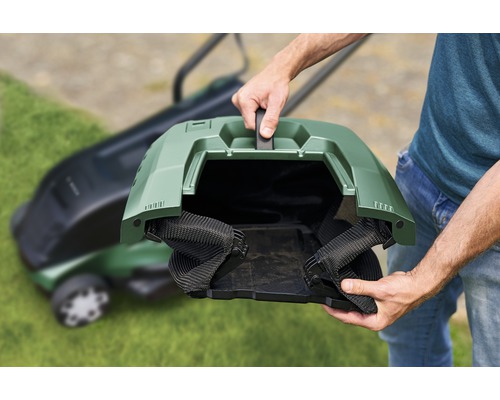 Persoon houdt de grasopvangbak van een grasmaaier vast