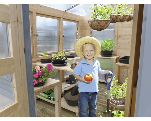 Kas met jongen, planten en tuingereedschap