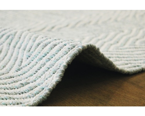 Detailopname van een vloerkleed met zigzagpatroon.