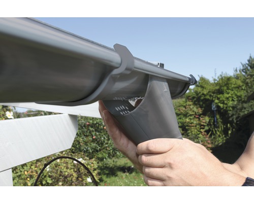 Installatie van een dakgoot door een persoon in de buitenlucht