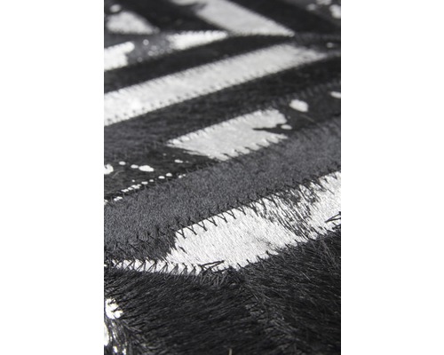 Detailopname van een zwart-wit vloerkleed met zigzagpatroon van vacht