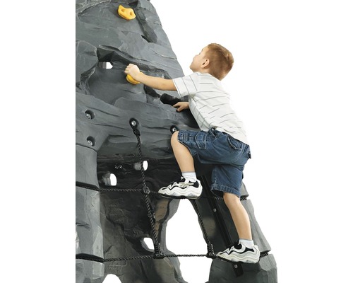 Kind klimt op een grijze klimwand met gele handgrepen en een zwart touwnet.