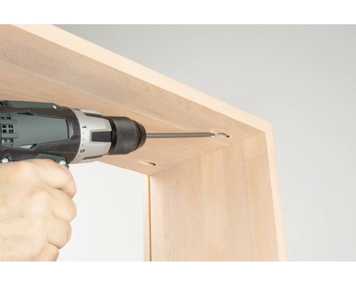 Accuboormachine bij het inschroeven van een schroef in een houten meubel