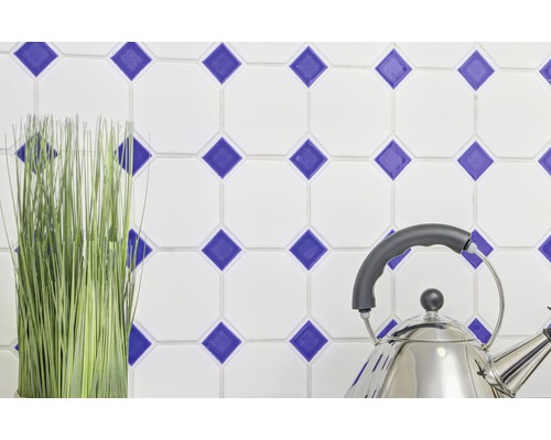 Decoratieve wandtegels met blauw ruitpatroon, roestvrijstalen fluitketel en kunstplant