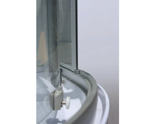 Detailopname van een douchecabine met glazen wanden en rolmechanisme