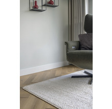 Woonkamer met fauteuil, tapijt en wandplanken