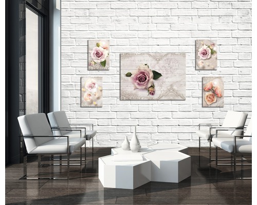 Woonkamer met witte stoelen, tafel en muurafbeeldingen met rozenmotieven op een bakstenen muur