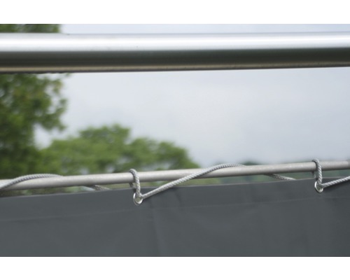 Detailopname van een zonnescherm met touwbevestiging aan een metalen frame