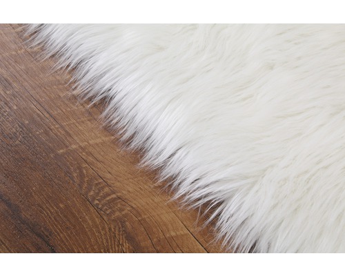 Gedetailleerd beeld van een wit tapijt op een houten vloer