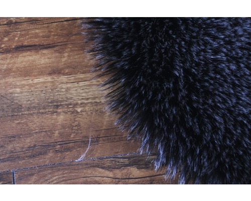 Close-up van een deel van een hoogpolig tapijt op een houten vloer