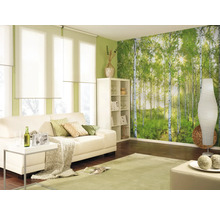 Lichte woonkamer met bank, plank, staande lamp, tapijt en bosbehang