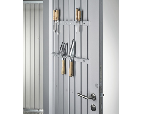 Tuin gereedschap hangt aan een metalen deur ter opslag.