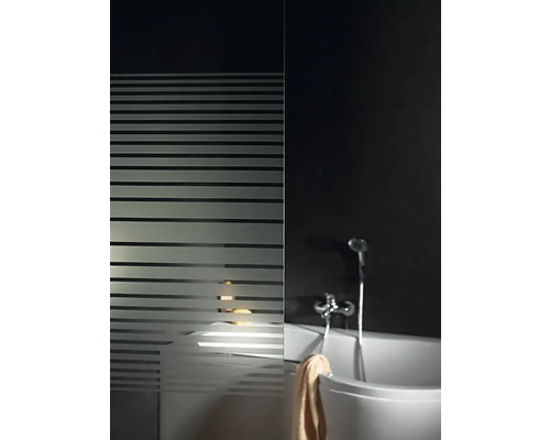 Badkamer met ligbad, douchearmatuur en douchewand met streepjesmotief