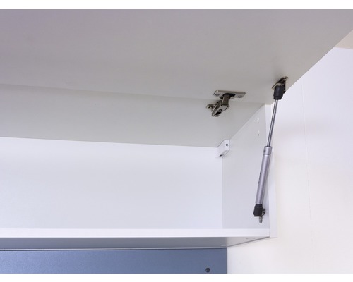 Binnenaanzicht van een witte keukenkast met scharnieren en gasveer