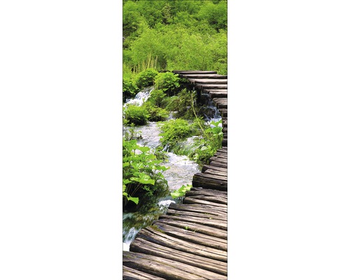 Houten loopbrug over een beek in een groen landschap