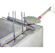 Beton wordt met een schop in een bekistingssteen gegoten.