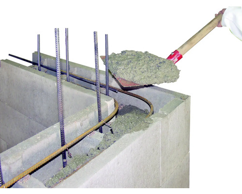 Beton wordt met een schop in een bekistingssteen gegoten.