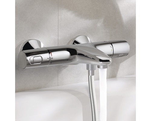 Opbouwthermostaatkraan in badkamer met stromend water.