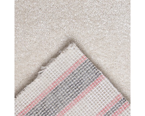 Close-up van een lichtgekleurd tapijt met textielrug