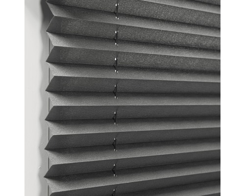 Close-up van een grijs plisségordijn voor raamdecoratie en zonwering.