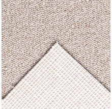 Detail van een beige tapijt met antisliprug.