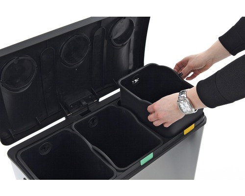 Afvalscheidingssysteem met drie bakken en een persoon die een bak plaatst