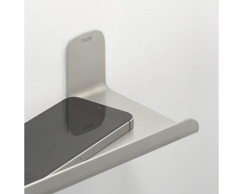 Tiger logo. Telefoontablet van metaal aan de muur met mobiele telefoon.