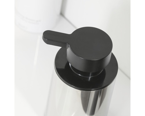 Detailopname van een zeepdispenser met zwarte pompknop en reservoir