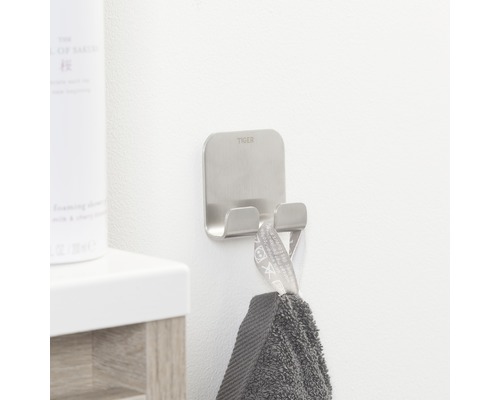 Tiger Logo op een zilverkleurige handdoekhaak met een grijze handdoek.