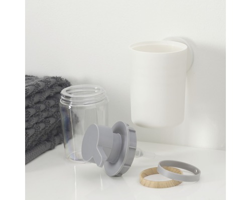 Zeepdispenser, tandenborstelbeker en handdoek op een plank