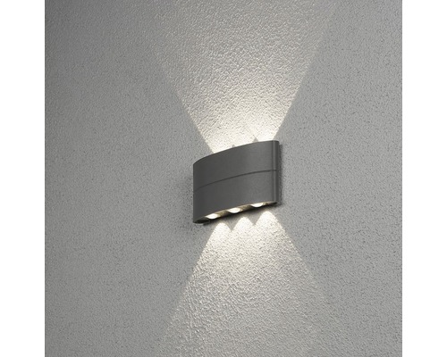 Grijze wandlamp met lichtstralen op de muur