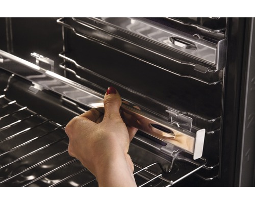 Een hand schuift een telescopische rail in een oven.