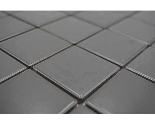 Detailopname van vierkante, grijze keramische tegels.