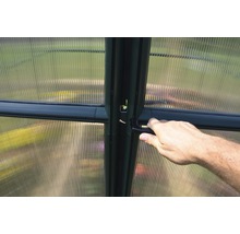 Detail van een kas met een hand aan de deurklink