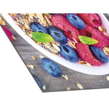 Close-up van een kom met muesli, frambozen, blauwe bessen en munt op een houten tafel