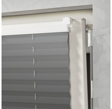 Detailopname van een grijs plisségordijn in een raamkozijn