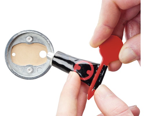 Een lijmtube wordt geopend met een rode applicator om lijm aan te brengen