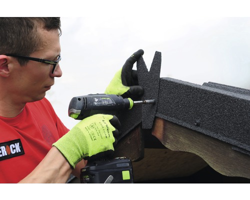 Man bevestigt dakshingles met een accuschroevendraaier
