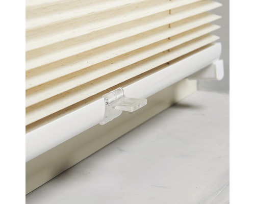 Close-up van een beige plisségordijn met witte beugel voor raamdecoratie.